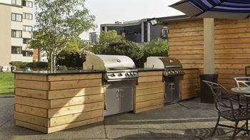 A small outdoor kitchen with a grill and sink at Skye at Belltown Apartments, Seattle, Washington